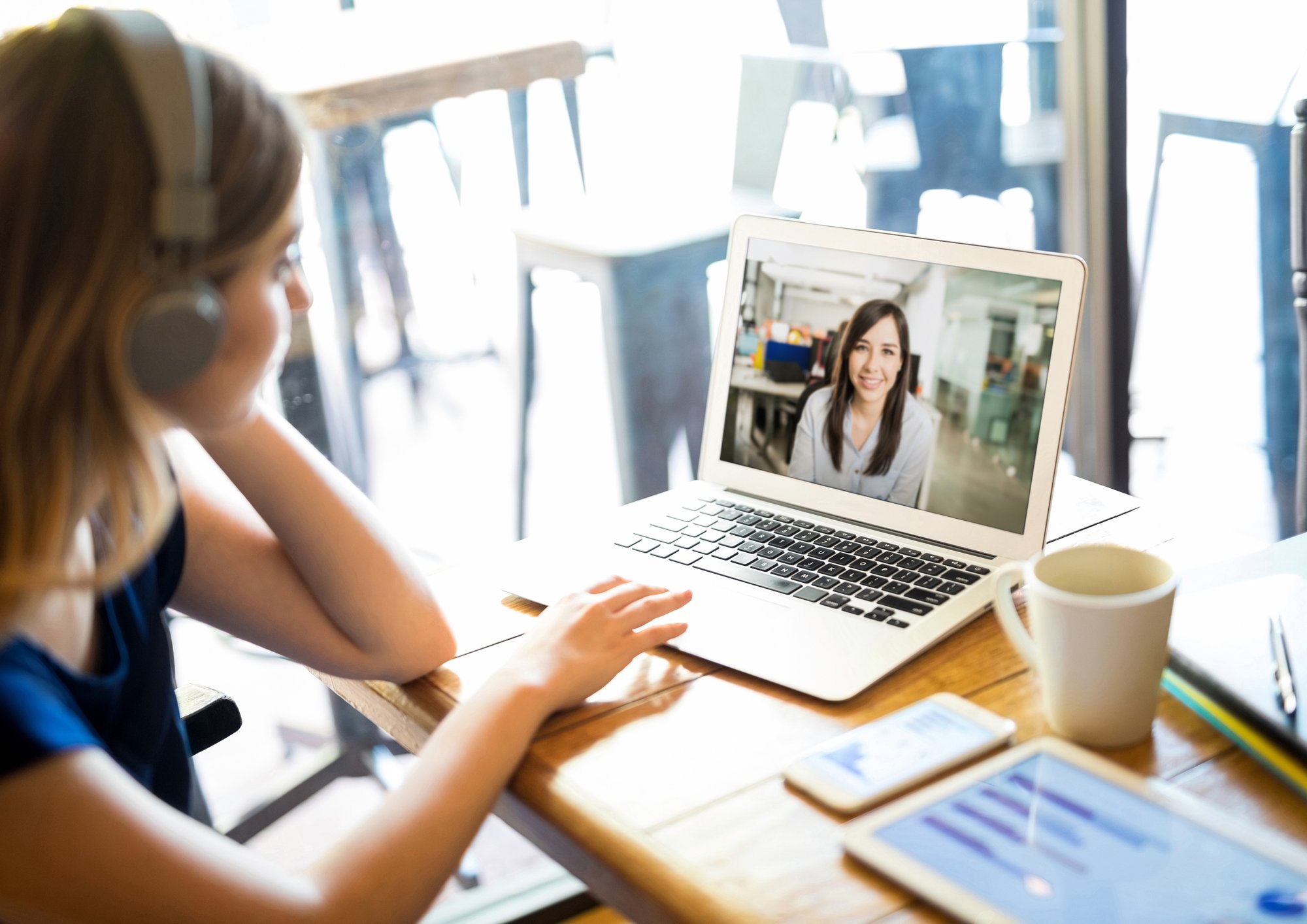 Bild einer Frau, die sie ein Webinar auf dem Laptop vor ihr auf einem Schreibtisch ansieht.